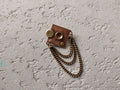 Square brooch with chain and disc embellishments
